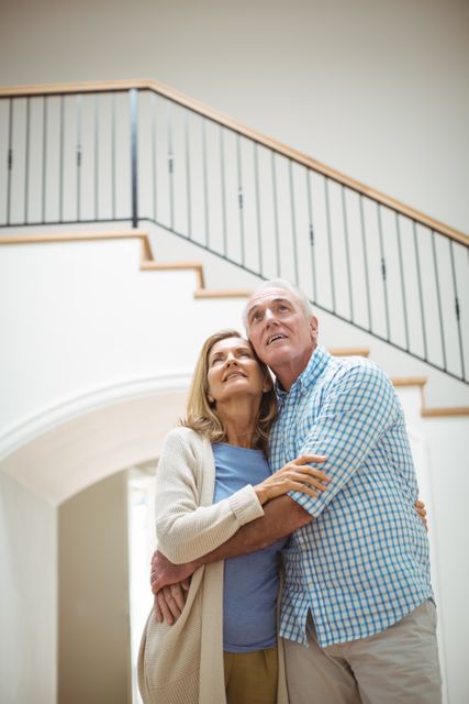 Senior couple embracing each other in living room at home