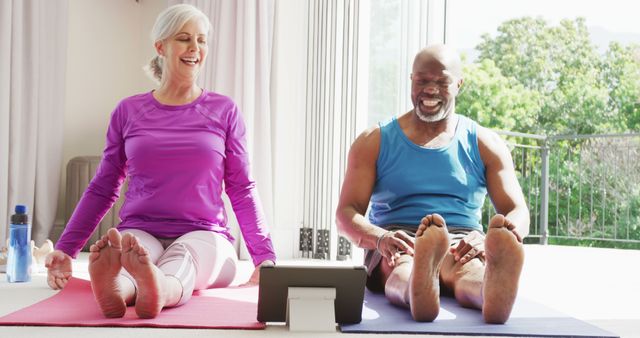 Happy senior diverse couple practicing yoga and stretching. Spending quality time at home and retirement concept.