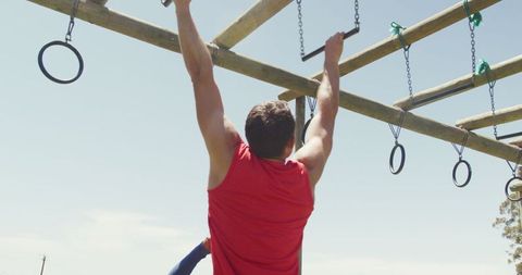 Man Conquering Monkey Bars on Outdoor Fitness Challenge