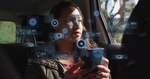 Holding smartphone and viewing holographic augmented reality interface in car back seat