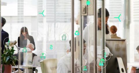 Corporate team collaborating in glass-walled office with green sustainability and finance icons