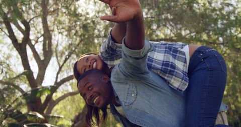 Playful Couple Enjoying Piggyback Ride Outdoors