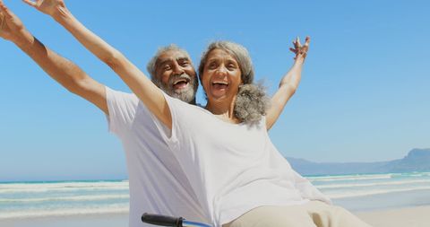 Joyful Senior Couple Enjoys Beachfront Bike Ride