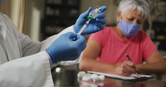 Healthcare Professional Preparing Vaccine with Senior Woman Taking Notes - Download Free Stock Images Pikwizard.com