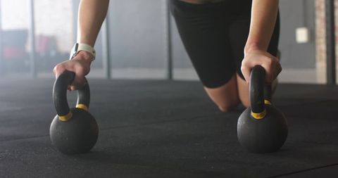 Female Athlete Training with Kettlebells in Gym