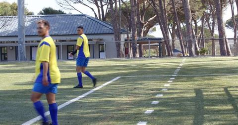 Soccer Players in Yellow Jerseys Training on Sunny Field