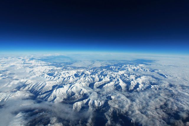 Aerial View of Snow-Covered Mountain Range Under Clear Blue Sky - Download Free Stock Photos Pikwizard.com