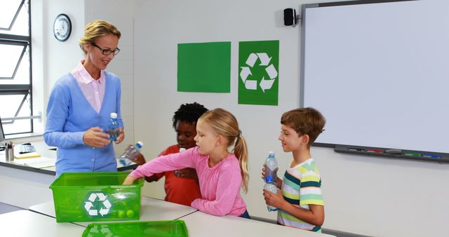 School kids putting bottle in recycle logo box in classroom at school 4k