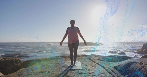 Woman Practicing Yoga on Rocky Shoreline at Sunrise