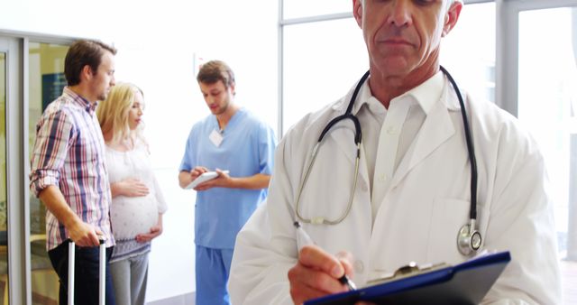 Expecting Couple in Hospital Hallway with Doctor and Nurse - Download Free Stock Images Pikwizard.com