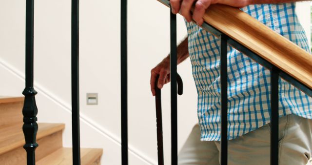 Mid section of senior man climbing upstairs with walking stick at home - Download Free Stock Photos Pikwizard.com