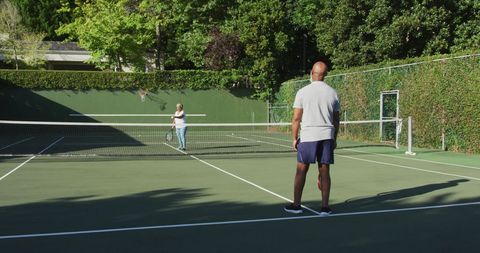 Senior Couple Playing Tennis on Sunny Court - Download Free Stock Images Pikwizard.com