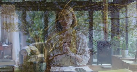Contemplative Chinese Woman Writing at Home Desk with Double Exposure Tree Branches