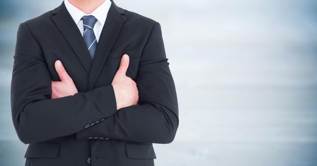 Businessman in professional attire standing with arms crossed. Great for business, leadership, corporate presentations, and professional websites. Ideal for conveying confidence and authority in business contexts.
