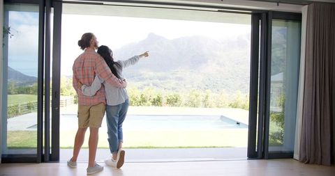 Couple enjoying scenic mountain view from modern home interior