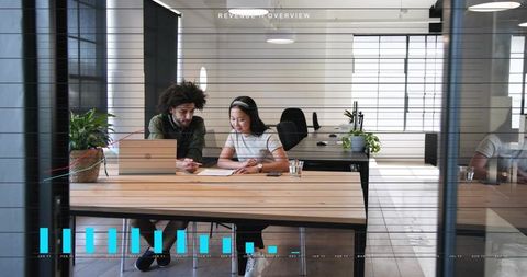 Collaborating on Reports in Modern Glass Office with Laptop Papers Plants and Data Overlay
