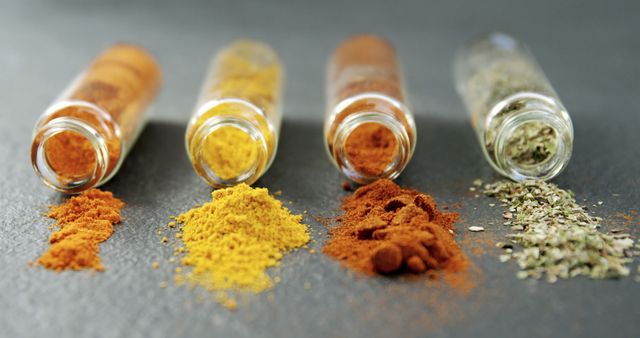 Assortment of Colorful Spices Spilled from Glass Vials on Black Surface - Download Free Stock Images Pikwizard.com