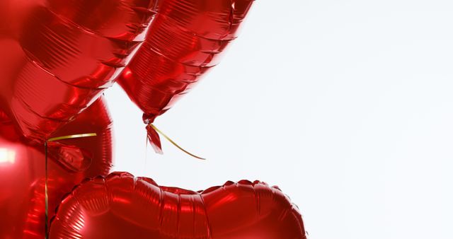 Red heart-shaped balloons fill the right side of the frame, with copy space on the left. They symbolize love and celebration, often used for romantic occasions like Valentine's Day or anniversaries.