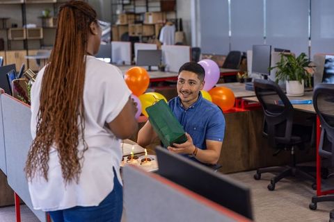 Coworker Gift Exchange with Balloons in Modern Office