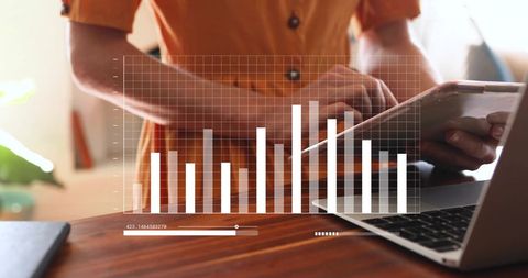 Businesswoman analyzing data on tablet and laptop