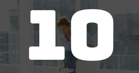 Young man adjusting laptop and smartphone in modern office workspace