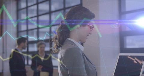 Businesswoman Analyzing Data on Laptop with Team in Modern Office