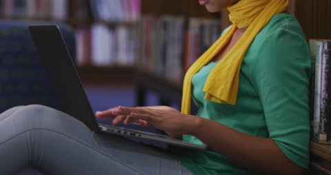 Focused Student Using Laptop in Library Floor Study Session