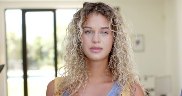 Young Woman with Curly Hair Standing in Sunny Room - Download Free Stock Images Pikwizard.com