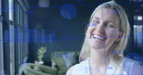 Smiling Professional Woman with Digital Graphs in Modern Office