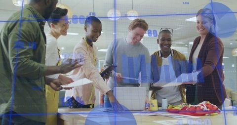 Diverse team collaborating over charts and product prototypes around office table