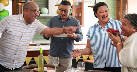 Diverse Seniors Enjoying Indoor Dinner Party Gathering