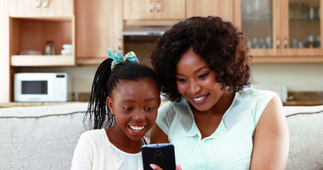 Mother and Daughter Smiling While Looking at Smartphone Together - Download Free Stock Images Pikwizard.com