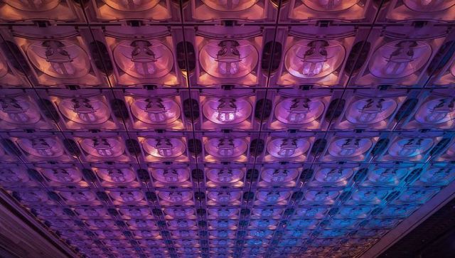 Glowing magenta-blue ceiling grid featuring mirror domes and gradient led lighting