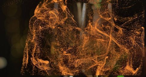 Swirling amber particle cloud with volumetric filaments, glowing orbs and bokeh lights