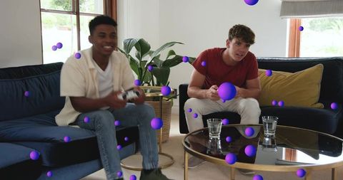 Friends playing video games on navy sofa with purple ar overlay and casual controllers