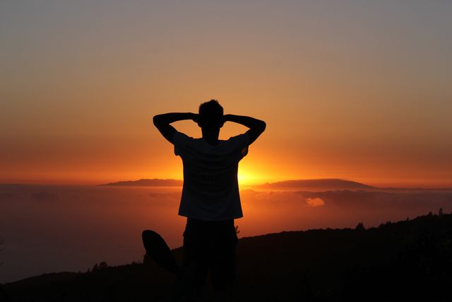 Silhouette Man Relaxing During Sunset Over Mountain Range - Download Free Stock Photos Pikwizard.com