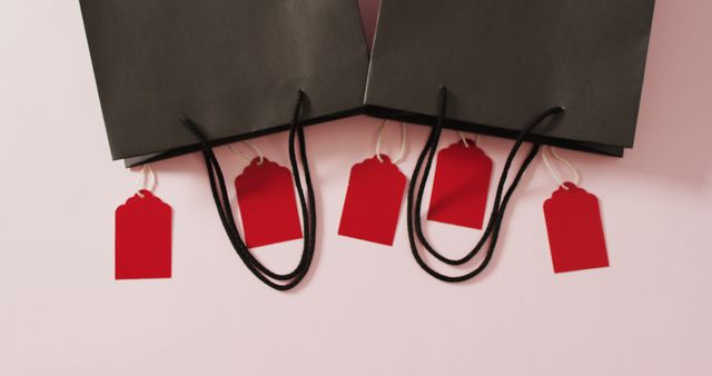 Two black gift bags with five red sale tags on white background with copy space - Download Free Stock Photos Pikwizard.com