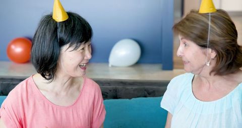 Senior female friends celebrating birthday with delightful joy
