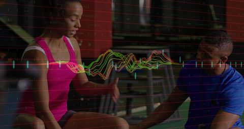 Trainer assisting athlete with leg stretch and biomechanics waveform data overlay