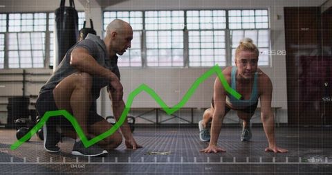 Female athlete performing plank while trainer coaching with fitness performance graph