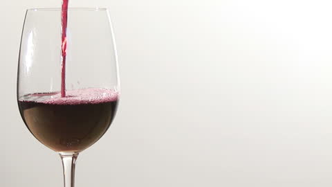 Pouring Red Wine into Glass in Minimalistic Setting