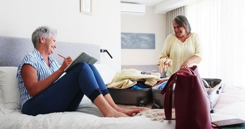 Senior Multiracial Lesbian Couple Organizing Vacation Packing Together