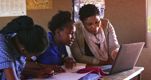 Teacher Guiding Students Using Laptop in Classroom - Download Free Stock Images Pikwizard.com