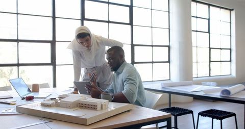 Architects collaborating on project with model and digital tools