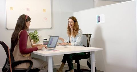 Diverse Female Coworkers Collaborating in Office Meeting Room