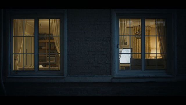 Two Lit Apartment Windows Revealing Cozy Bedroom and Living Room at Night