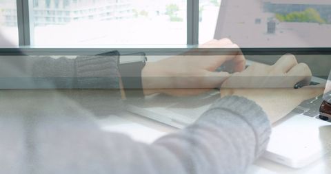 Hands typing on laptop with professional collaboration in office