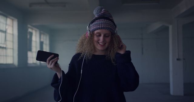 Happy Young Woman Listening to Music with Headphones in Urban Loft - Download Free Stock Images Pikwizard.com