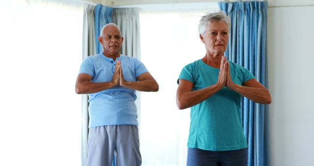 Senior citizens performing yoga at home