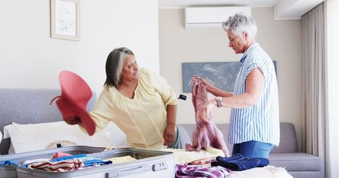 Senior Couple Packing for Vacation in Bedroom